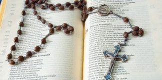 Catholic Books That Bring Reflection Into Everyday Life silver cross pendant necklace on book page